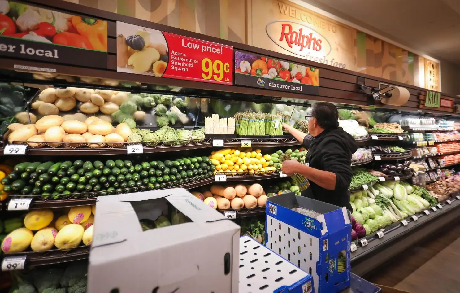 Shopper browsing fresh produce aisle at a U.S. supermarket, where Amex Gold cardholders earn 4x Membership Rewards points