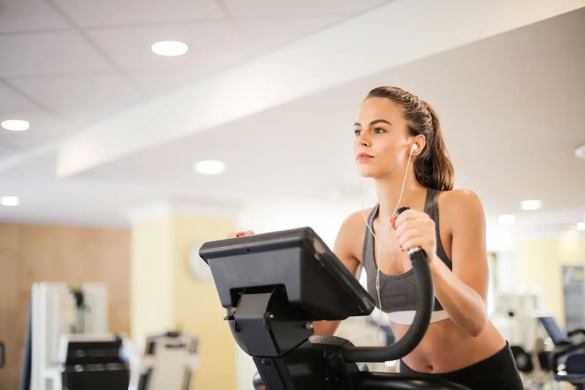 Woman working out on a stationary bike at the gym, representing Amex Platinum wellness credits
