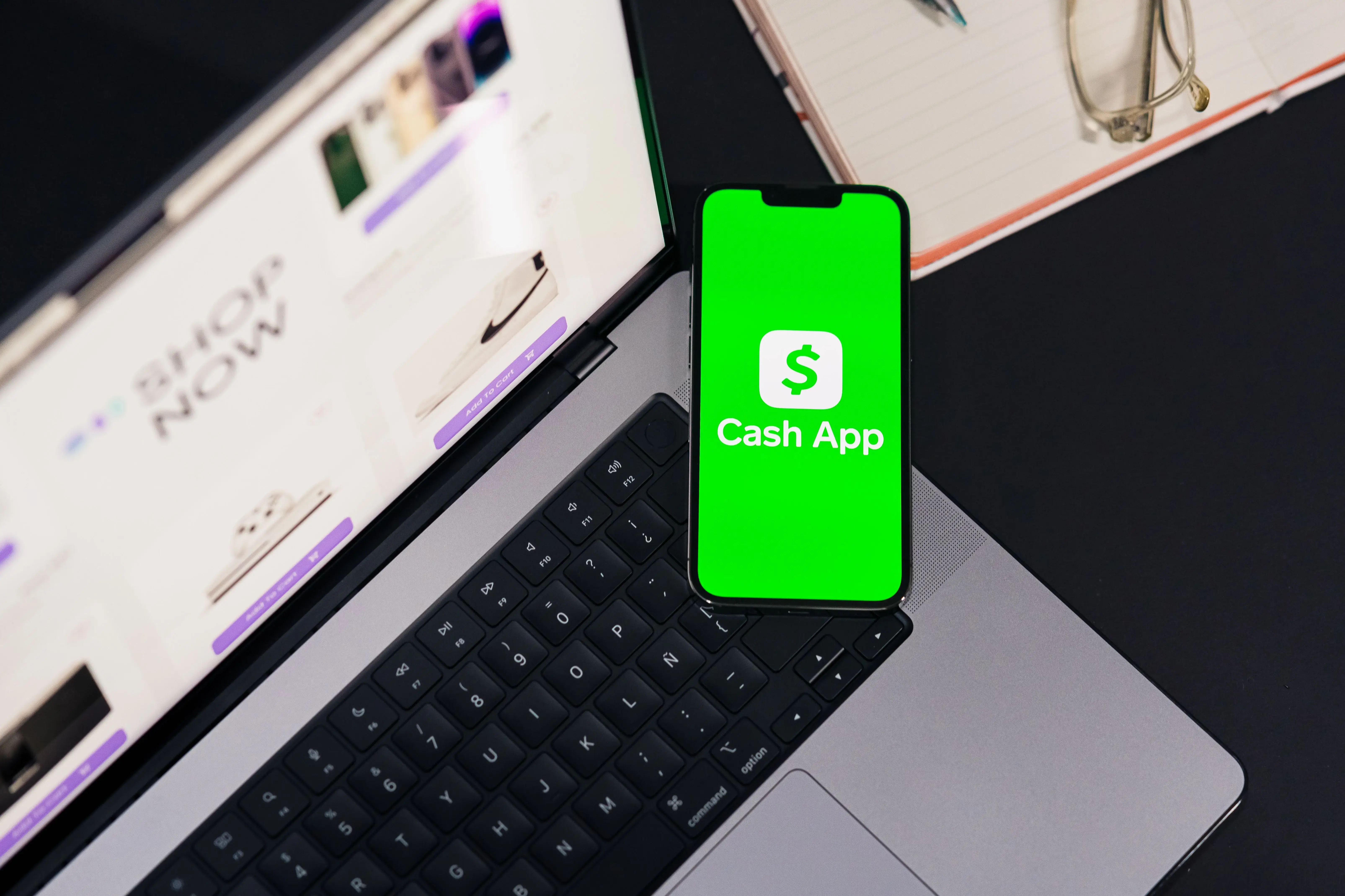 Cash App open on a smartphone next to a laptop, illustrating the risks of payment app scams