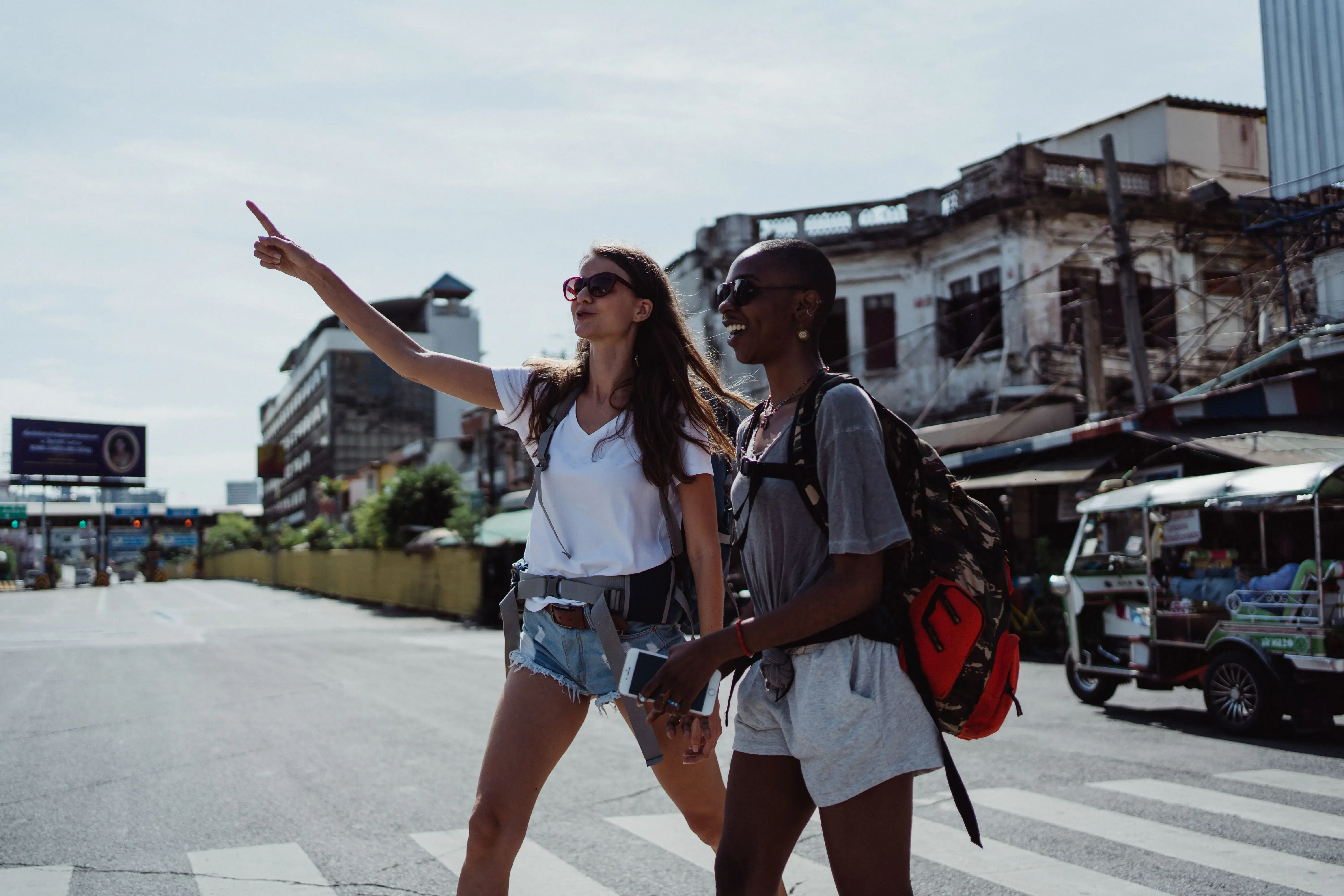 Two travelers with backpacks exploring a city street