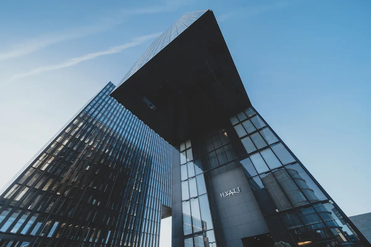 Looking up at a modern Hyatt hotel tower with glass facade, representing World of Hyatt points and the Chase Sapphire Preferred transfer ratio change