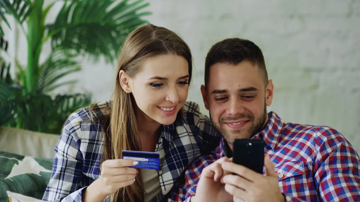 Couple reviewing Chase Sapphire Preferred credit card application on smartphone at home