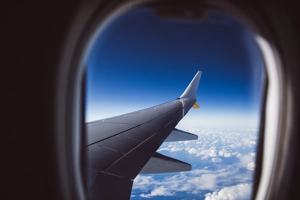 Airplane wing view at sunset, representing the Atmos Rewards Ascent card's new welcome bonus and companion fare offer