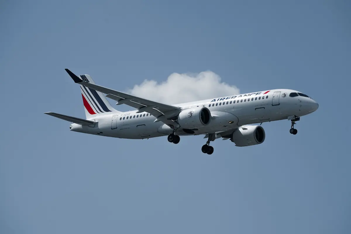 Air France Airbus A220 aircraft flying against a blue sky with clouds