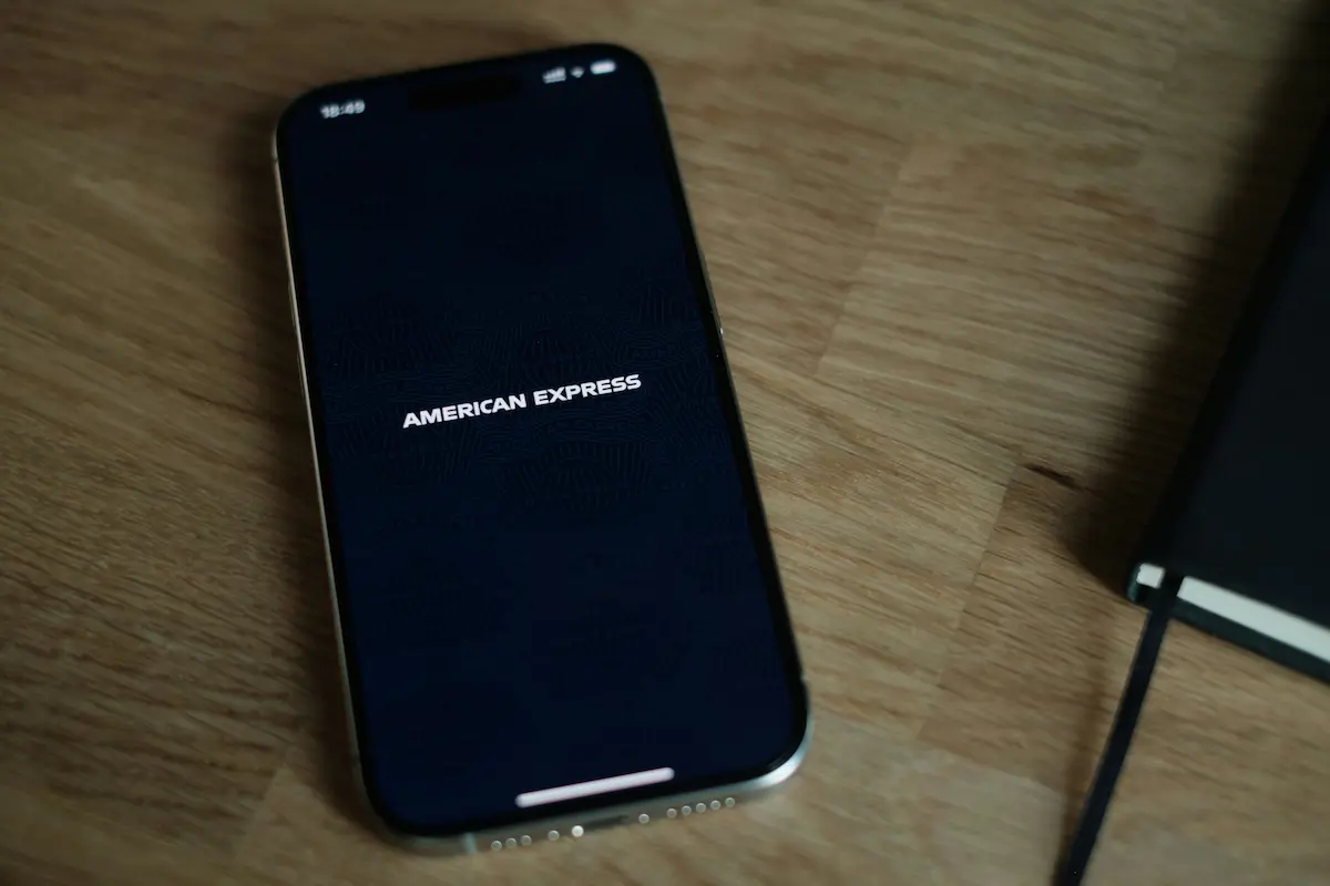 Smartphone displaying the American Express app on a wooden table