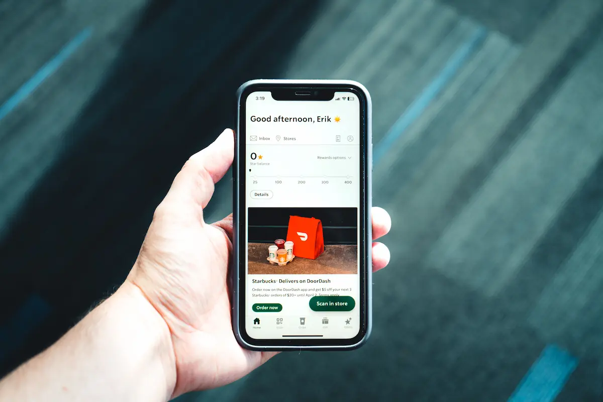 Phone showing a DoorDash order and Starbucks rewards screen, illustrating how to track Chase Sapphire Reserve DoorDash credits