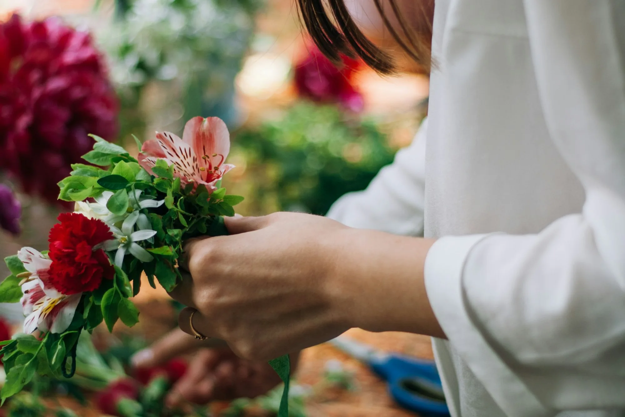 Florist arranging flowers behind the counter of a small shop