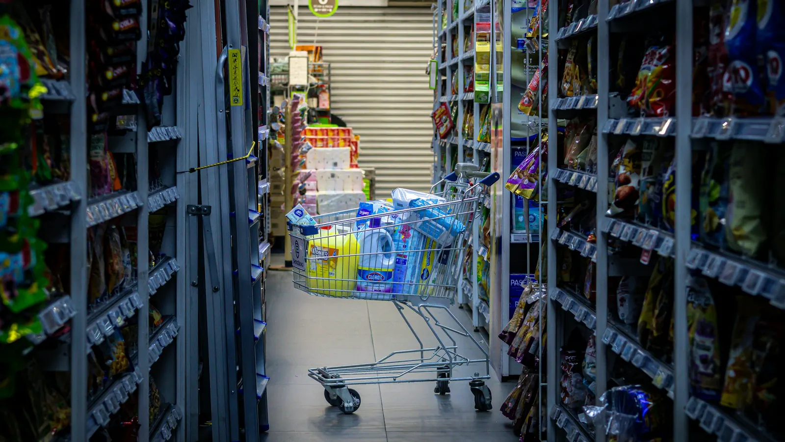 Shopping cart filled with groceries in a supermarket aisle