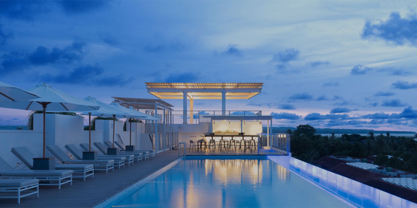Rooftop hotel pool and bar lit at dusk, illustrating the Chase Sapphire Reserve 10th anniversary hotel offers