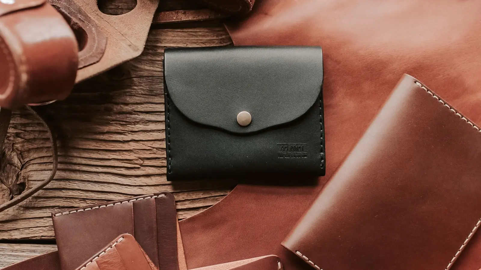 Leather wallets and card holders arranged on a wooden table