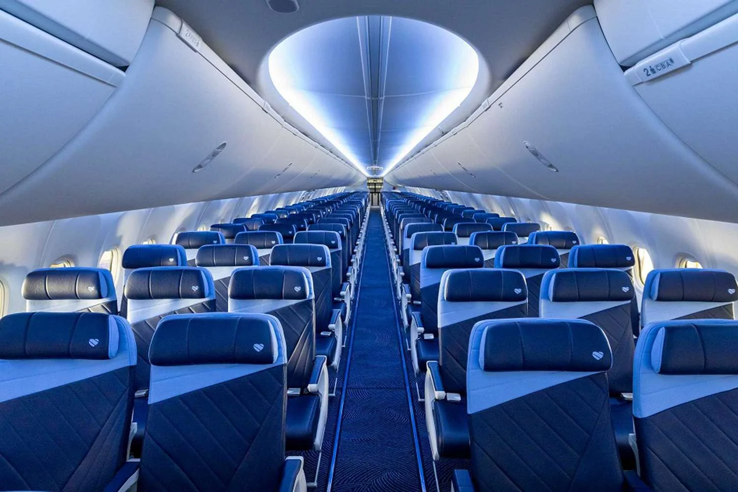 Southwest Airlines cabin interior with rows of blue seats and an overhead lighted ceiling