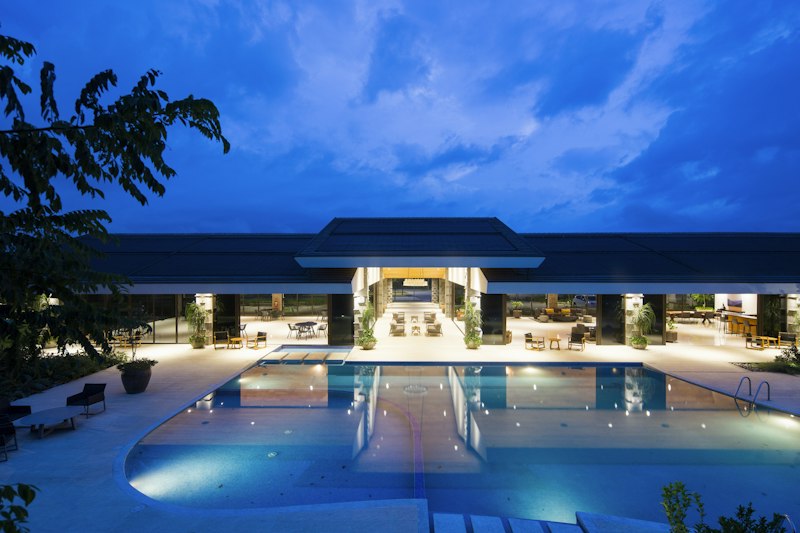 Hotel pool and open-air lobby lit up at dusk, illustrating the Marriott Bonvoy Business card's annual Free Night Award