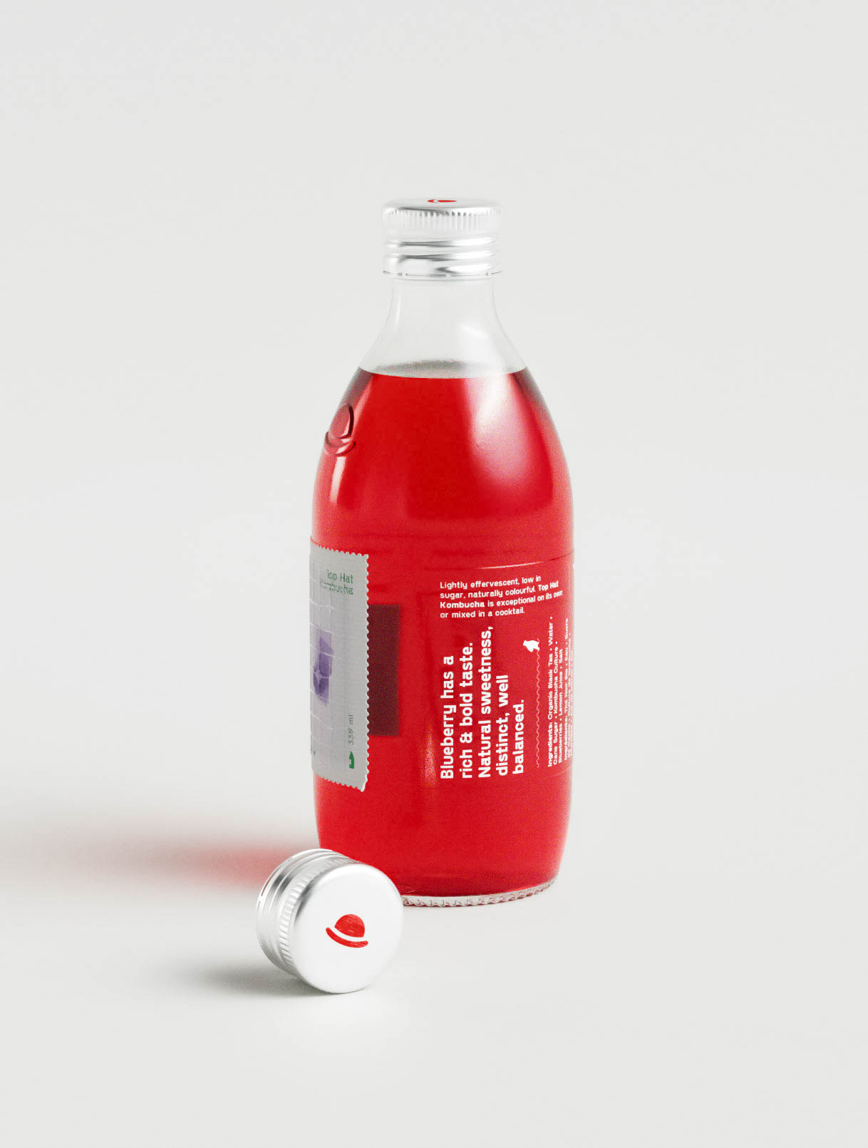 This image shows the back label of a kombucha bottle, emphasizing clear communication of product benefits. The text block—set in white against the ruby-red liquid—highlights the flavor profile of blueberry, describing it as bold, natural, and well balanced. A narrow vertical label maintains consistency with the front design, while embossed branding remains visible on the bottle’s shoulder. This packaging demonstrates how branding studios use layout, typography, and transparent hierarchy to clearly deliver brand messaging without compromising visual appeal.