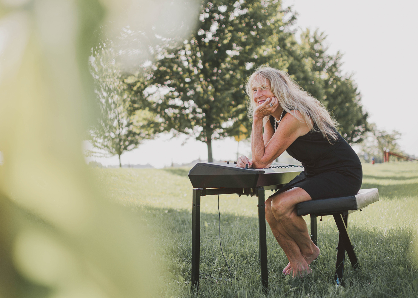 Woman sitting at a piano in a field
