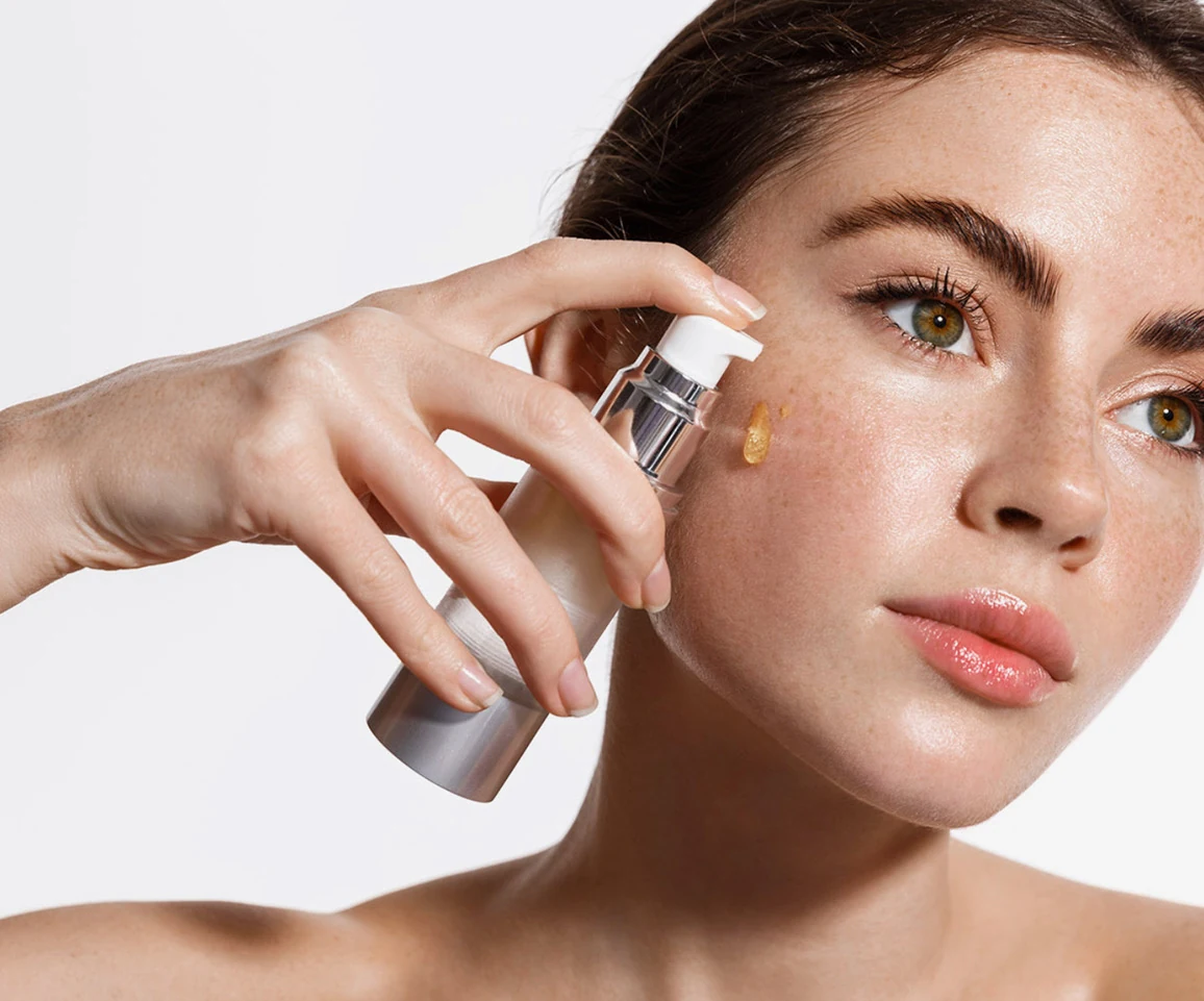 Woman applying lotion to her face.