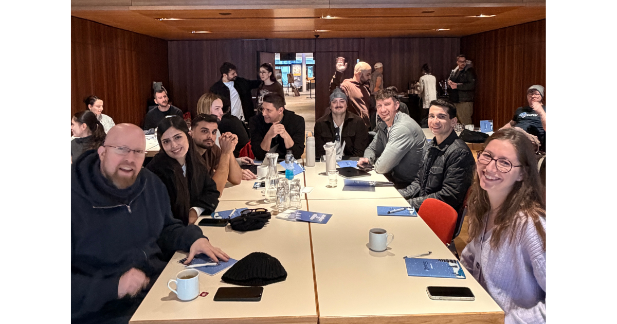 Anchor team members enjoying a coffee break at a table in a conference room.
