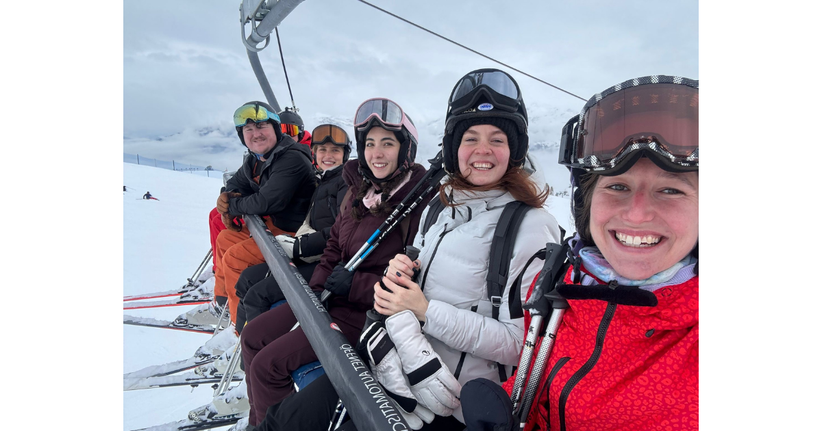 Anchor team members riding on a ski lift between the runs.