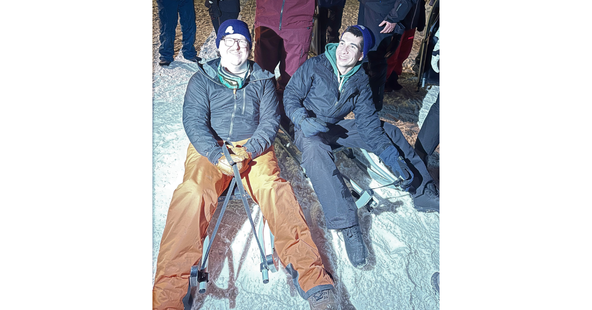 Members of Team Anchor, preparing for a nighttime toboggan run in the snow.