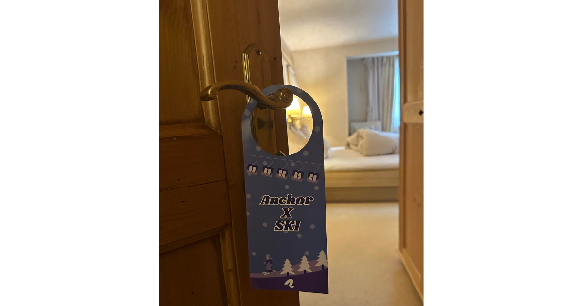 Image of a custom hotel door hanging sign that reads, "Anchor X Ski."