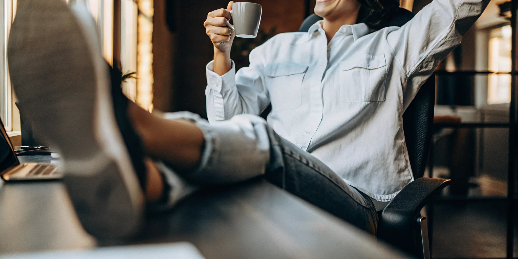 Firm owner enjoying coffee at a bright desk after automating billing