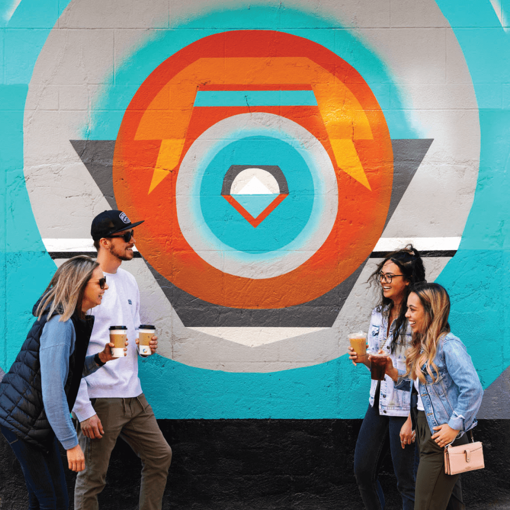 Four art lovers share
a laugh next to Exposure, a mural in downtown Medicine Hat.