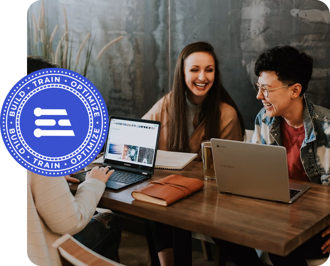 Three university students smiling and collaborating with laptops, symbolizing the Edge Impulse Campus Ambassador Program for student leadership and AI community engagement.