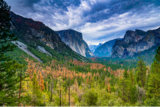 Green grass fills the land overshadowed by mountains.