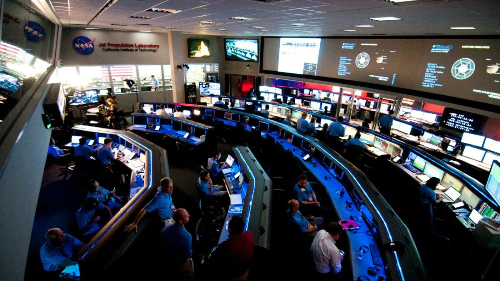 A group of people in a control roomAI-generated content may be incorrect.