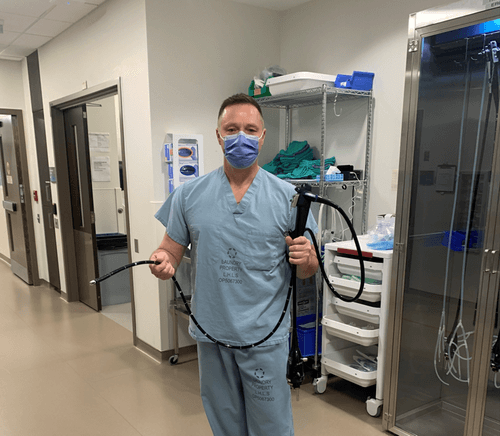 This is a picture of Dr. Paul Collins, holding up one of the new scopes purchased with donor support.