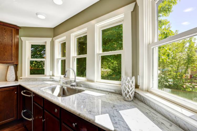 Kitchen with large windows, marble countertops.