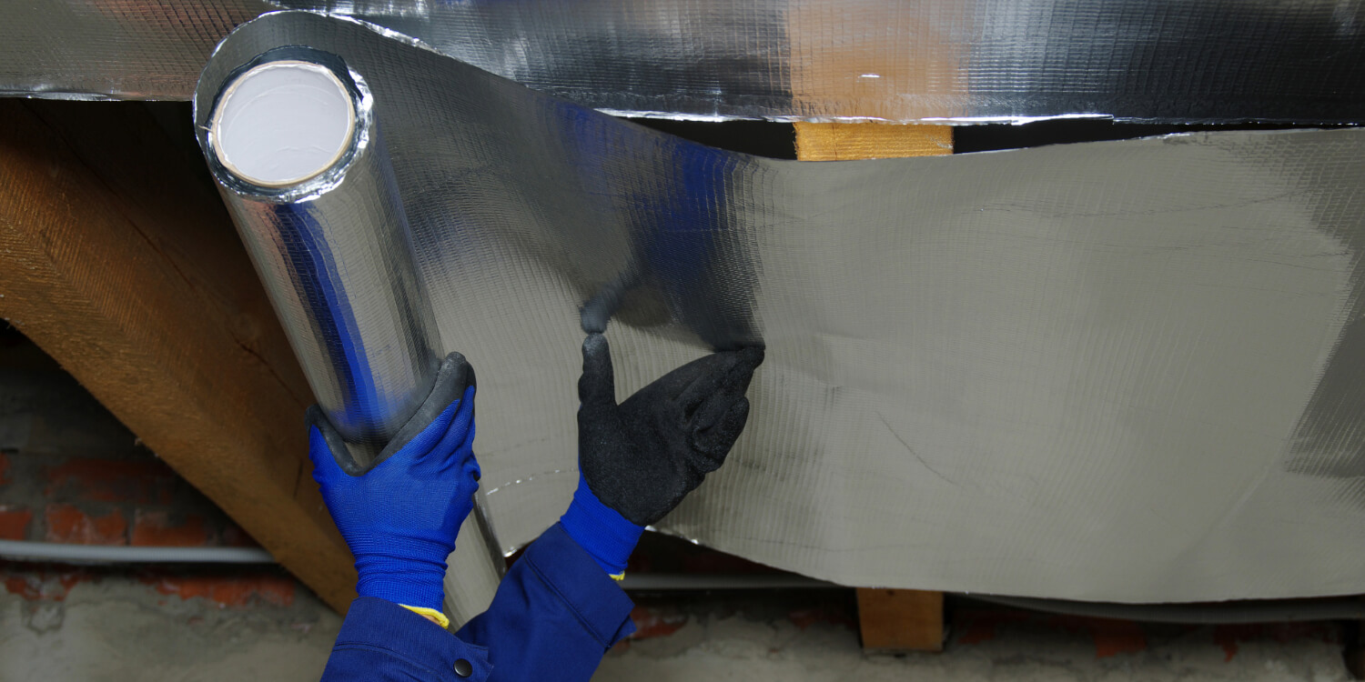 Person installing radiant barrier insulation.