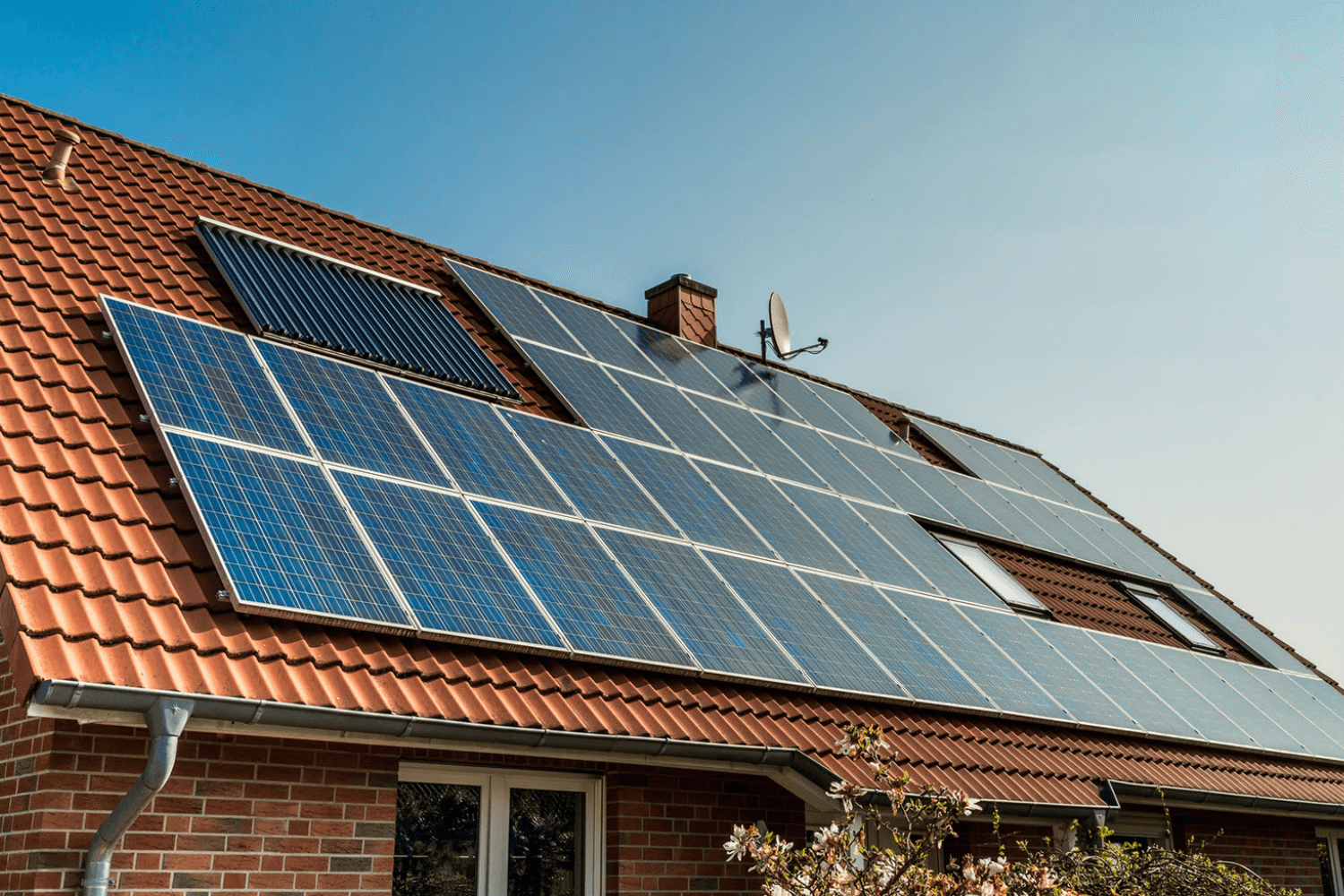 Red-roofed house with solar panels.
