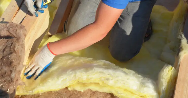 Person installing insulation in San Antonio home.