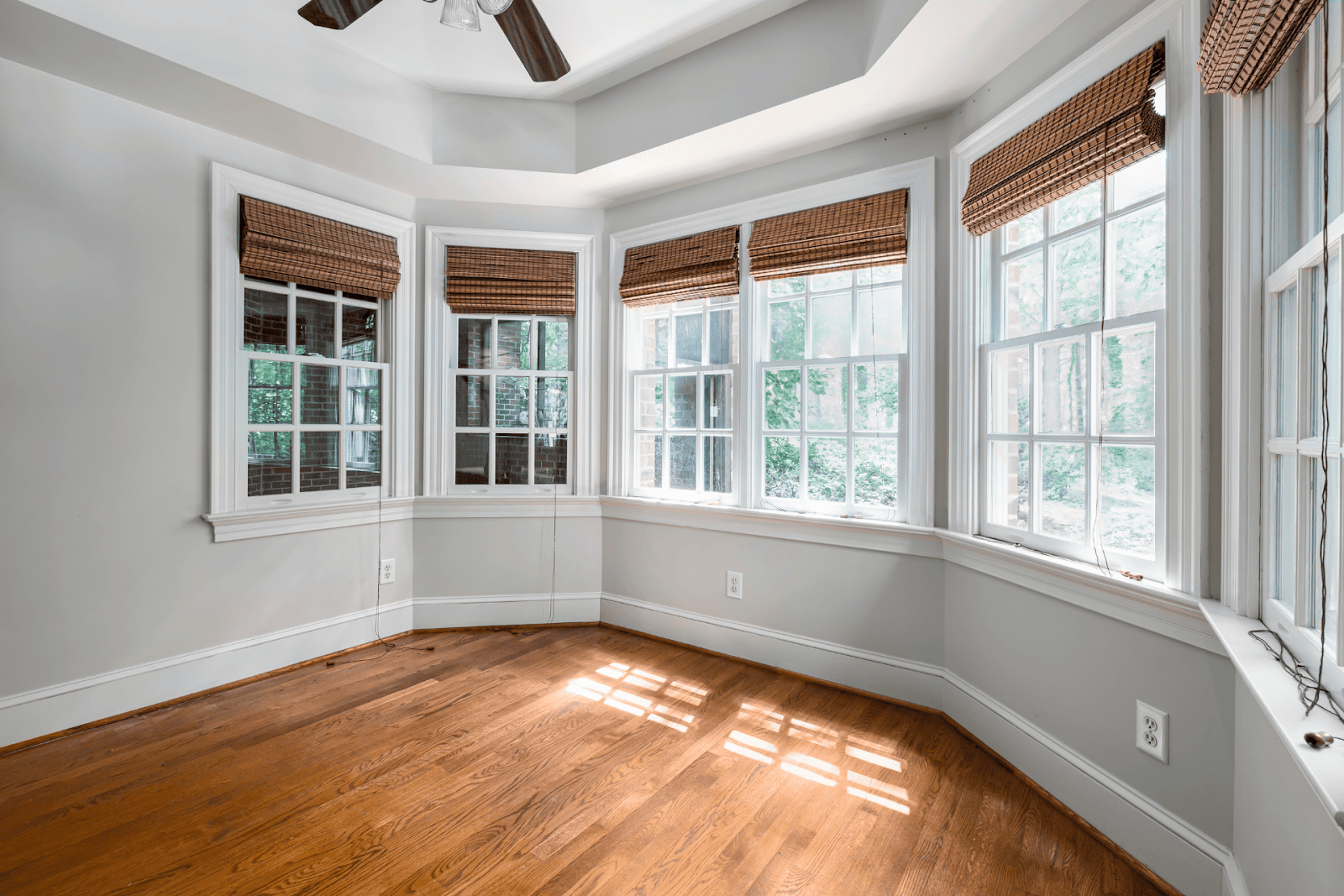 Bright room with hardwood floors and large bay windows letting in natural light.