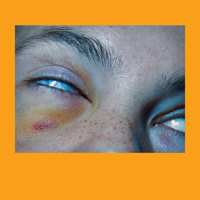 bright orange border around a close-up of a boy with his eyes rolled back into his head
