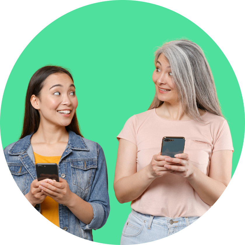 Dos mujeres sonrientes, una con cabello largo y oscuro y otra con cabello largo y canoso, sosteniendo teléfonos móviles.