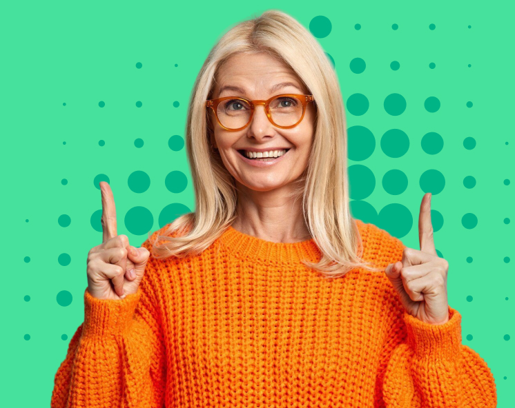 Mujer sonriente con suéter naranja, cabello rubio y gafas, señalando hacia arriba sobre fondo verde con círculos.