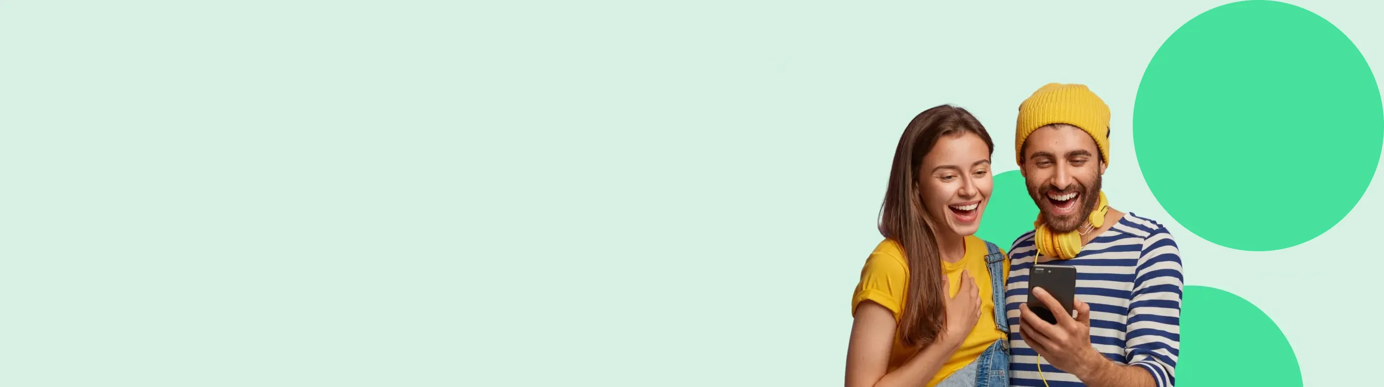 Pareja sonriente mirando un teléfono móvil, con fondo de color suave y círculos verdes. Ella lleva una camiseta amarilla y él un gorro amarillo.