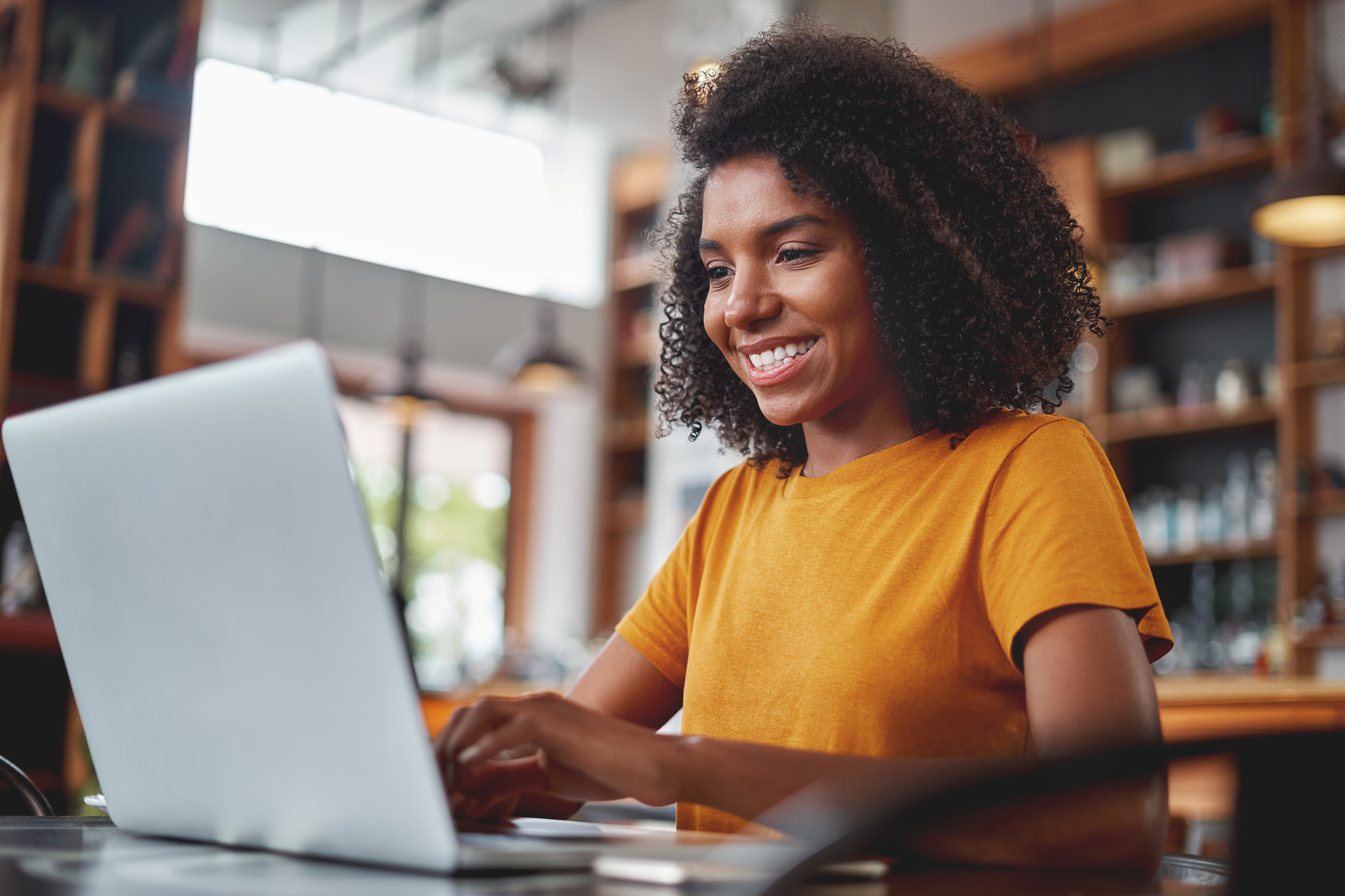 A smiling woman using a laptop.