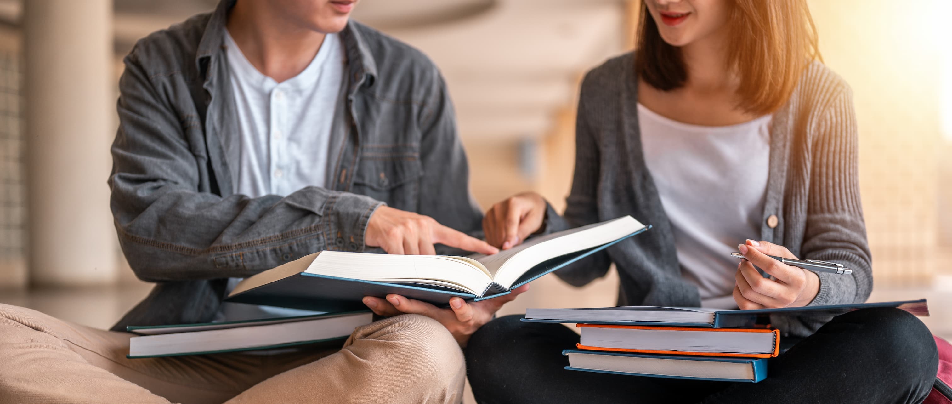 Two students examining a textbook.