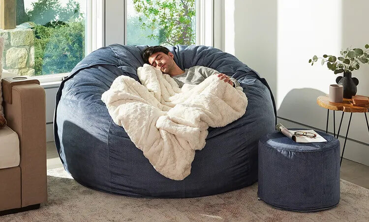 A man sleeping in a Lovesac couch