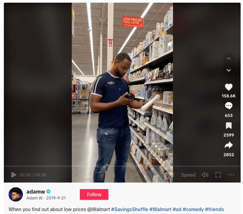 Store employee checks product in Walmart aisle with low prices sign