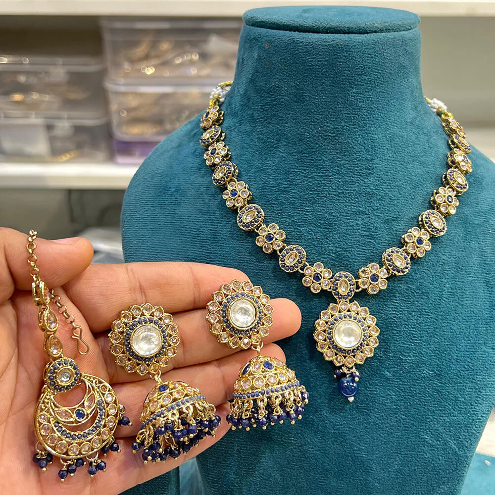Ornate gold and blue Indian jewelry set with kundan and blue beads