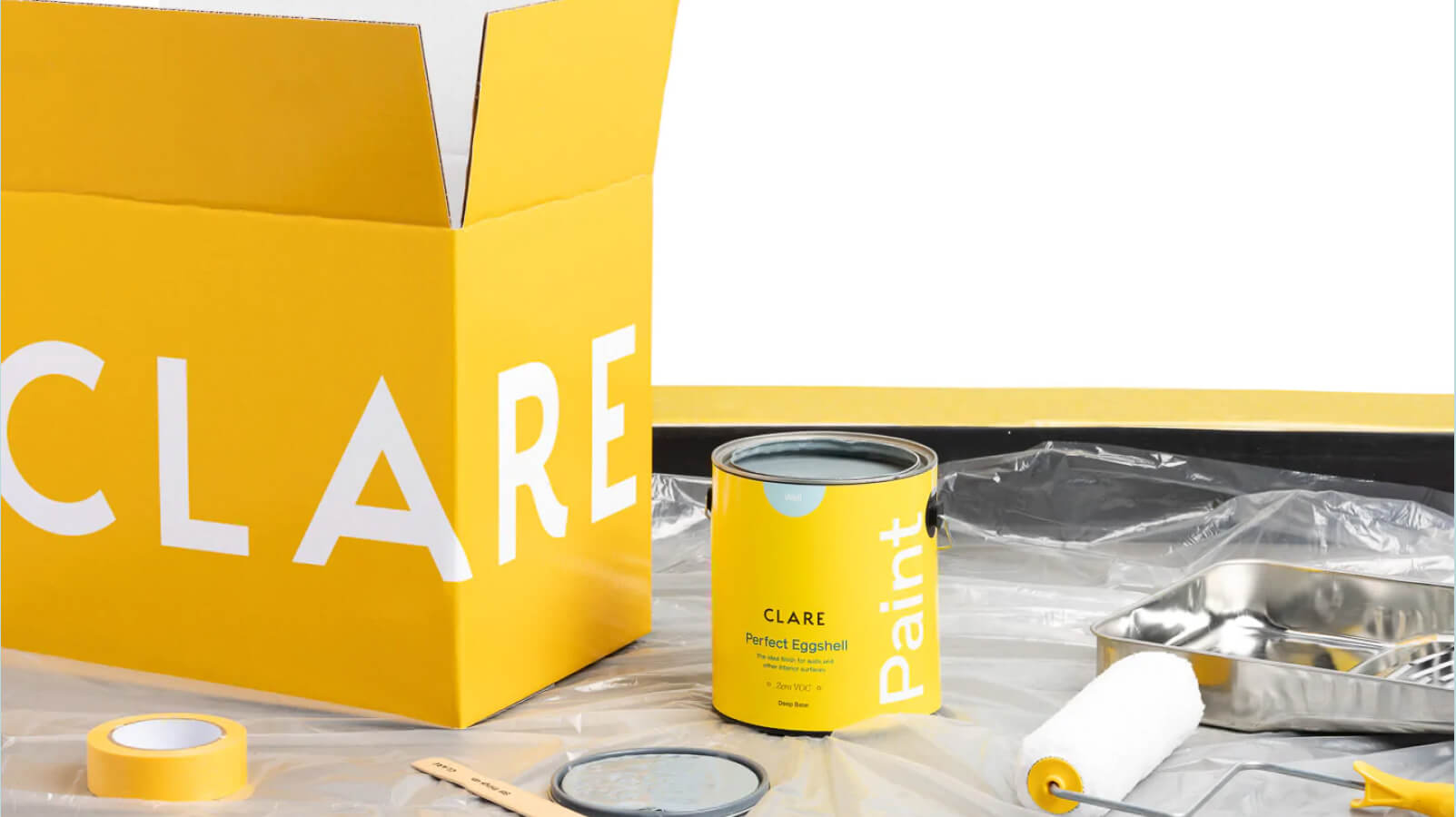 Clare paint supplies with yellow box, paint can, roller, and painting tools