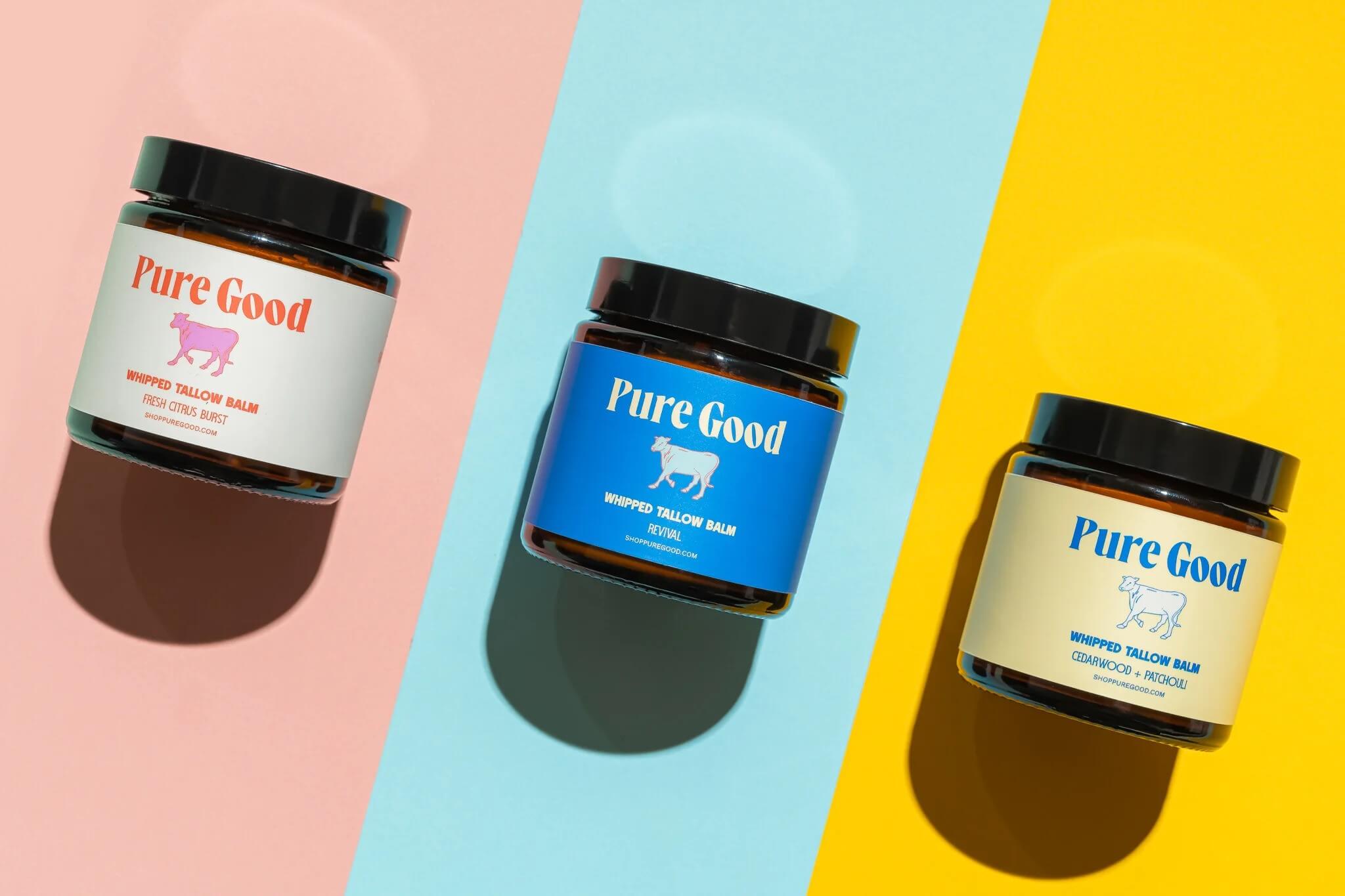 Three Pure Good whipped tallow balm jars on colorful background