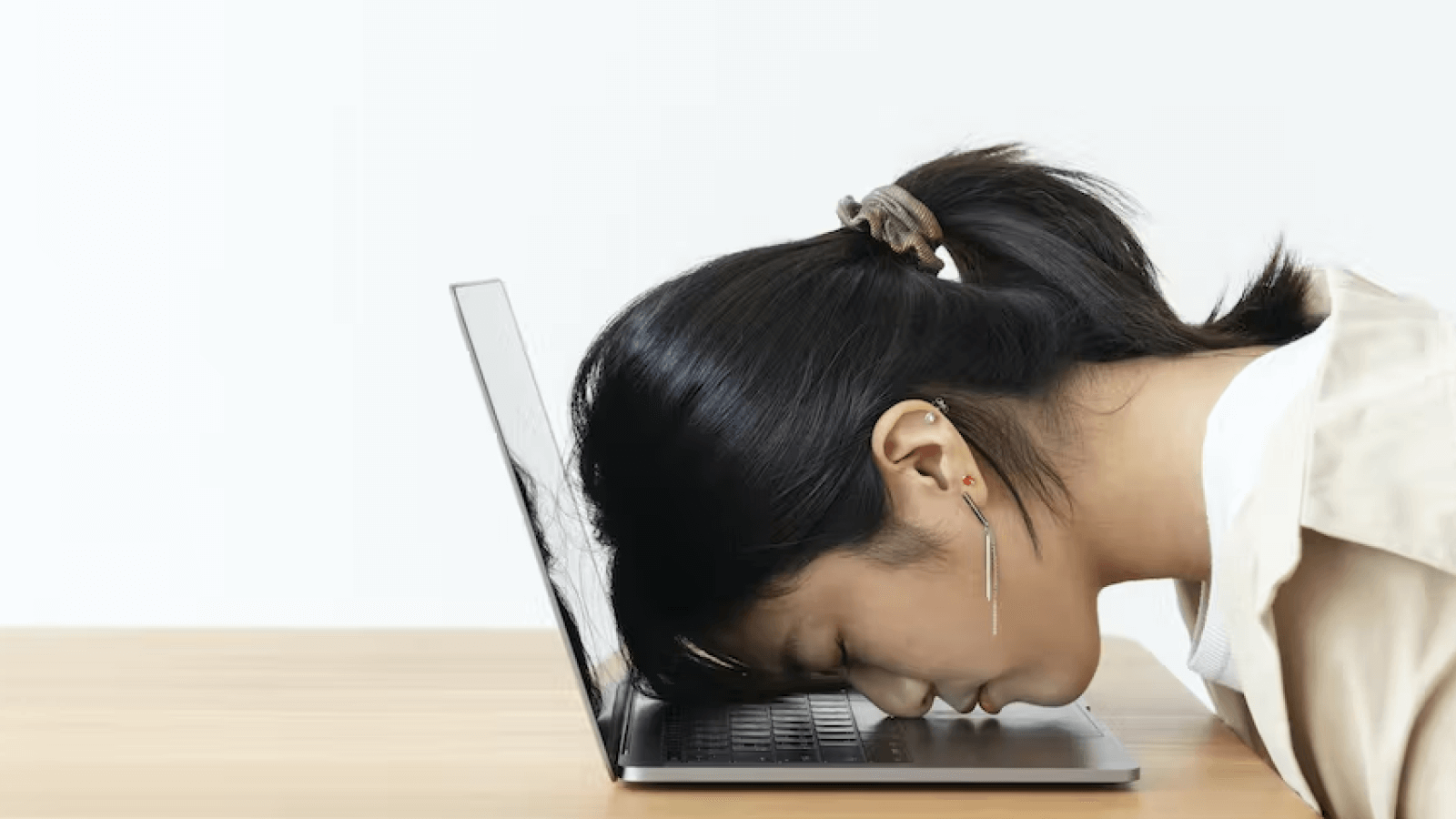 Exhausted person sleeping on laptop, depicting workplace burnout