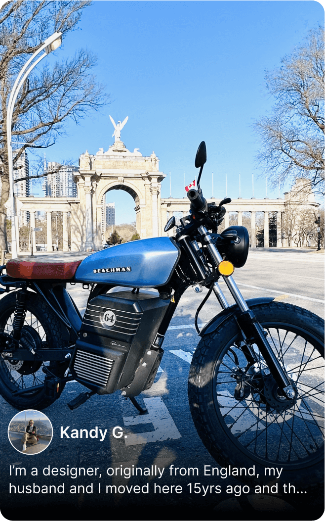 Blue Beachman electric motorcycle parked near historic arch in winter