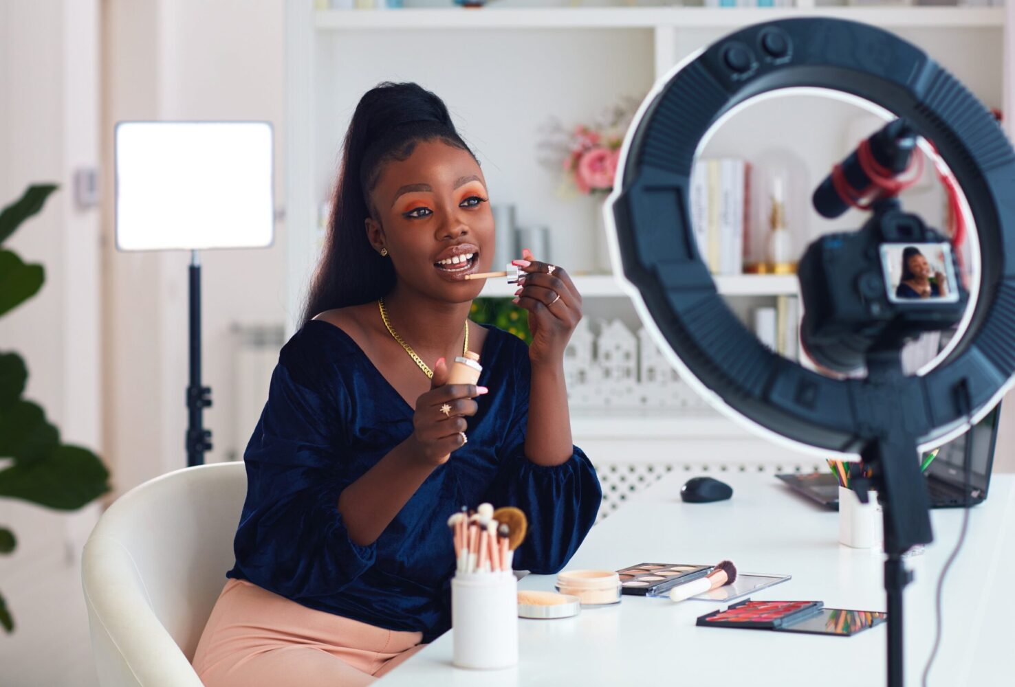 Beauty influencer recording makeup tutorial with ring light and camera