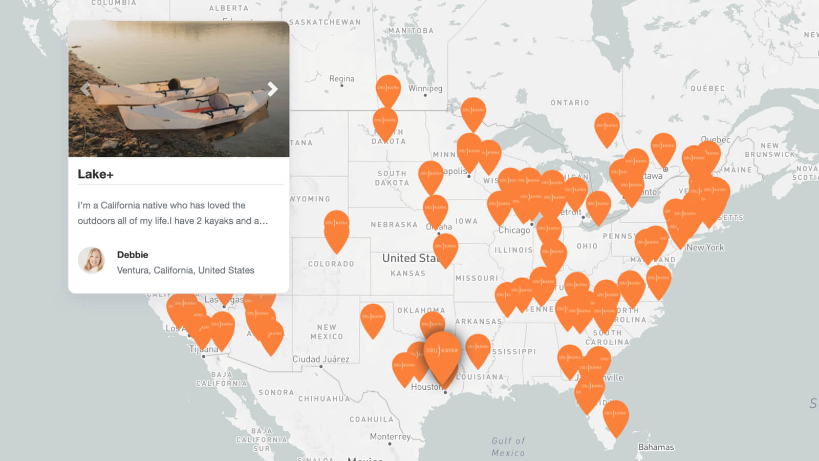 White kayak resting on rocky shore with calm water and misty background