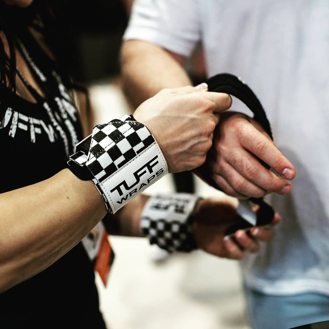 Hands wearing checkered Tuff Wraps wristbands during weightlifting or training